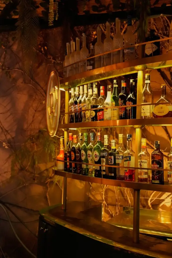 Mur de bouteilles en lumière tamisée du bar restaurant rôtisserie de la paix à Marrakech Quartier Guéliz - Photographe Restaurant Toulouse | Alba